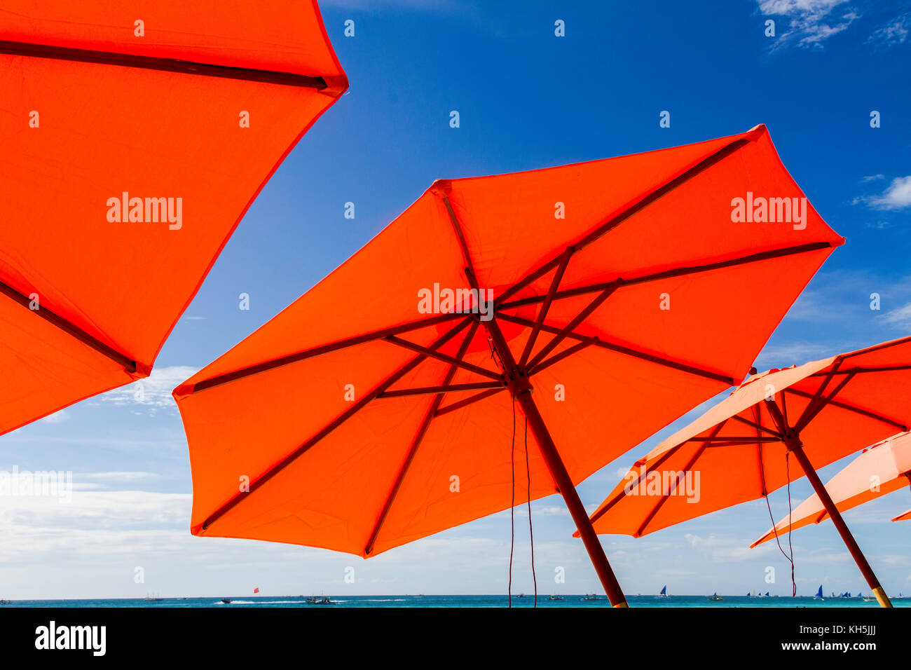 Colorato arancione ombrelloni sulle spiagge di Boracay, Visayas, Filippine Foto Stock