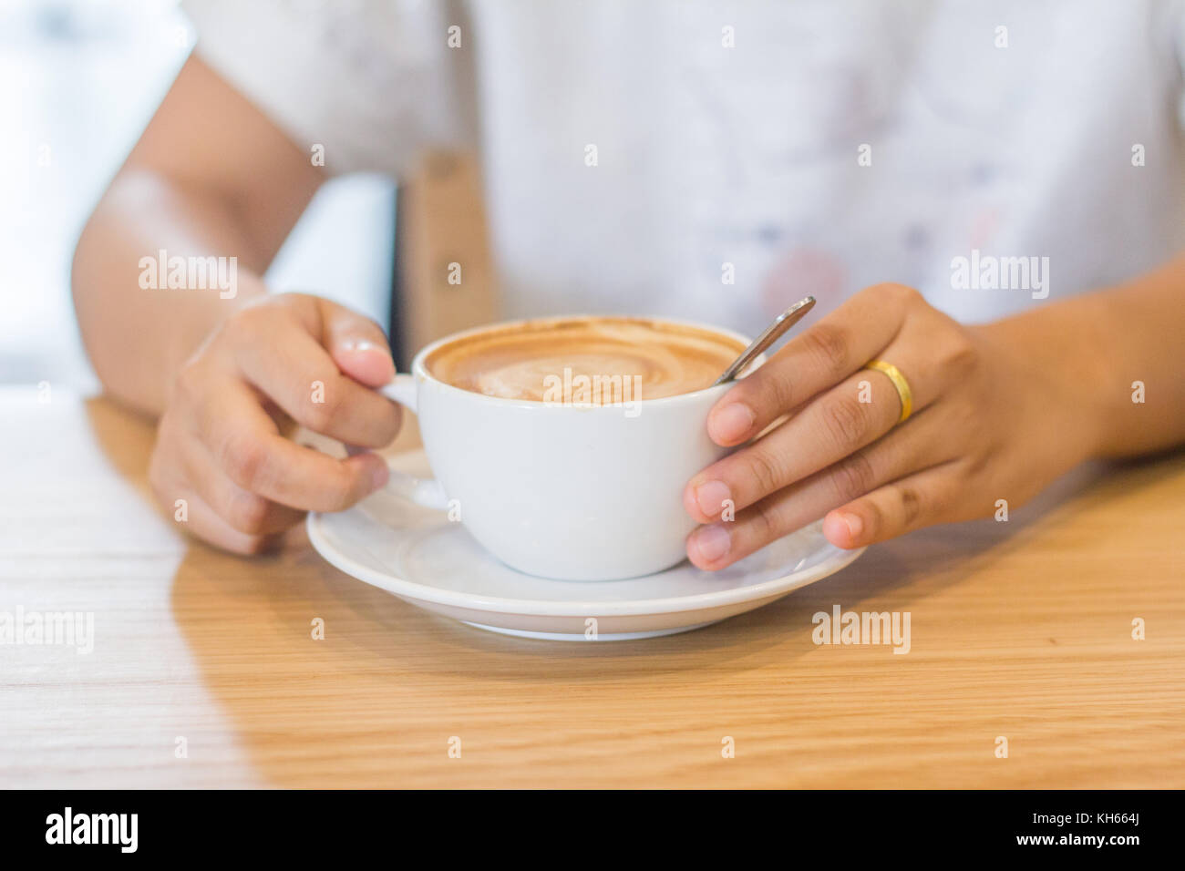 Le mani della giovane donna con il cacao in polvere cup Foto Stock