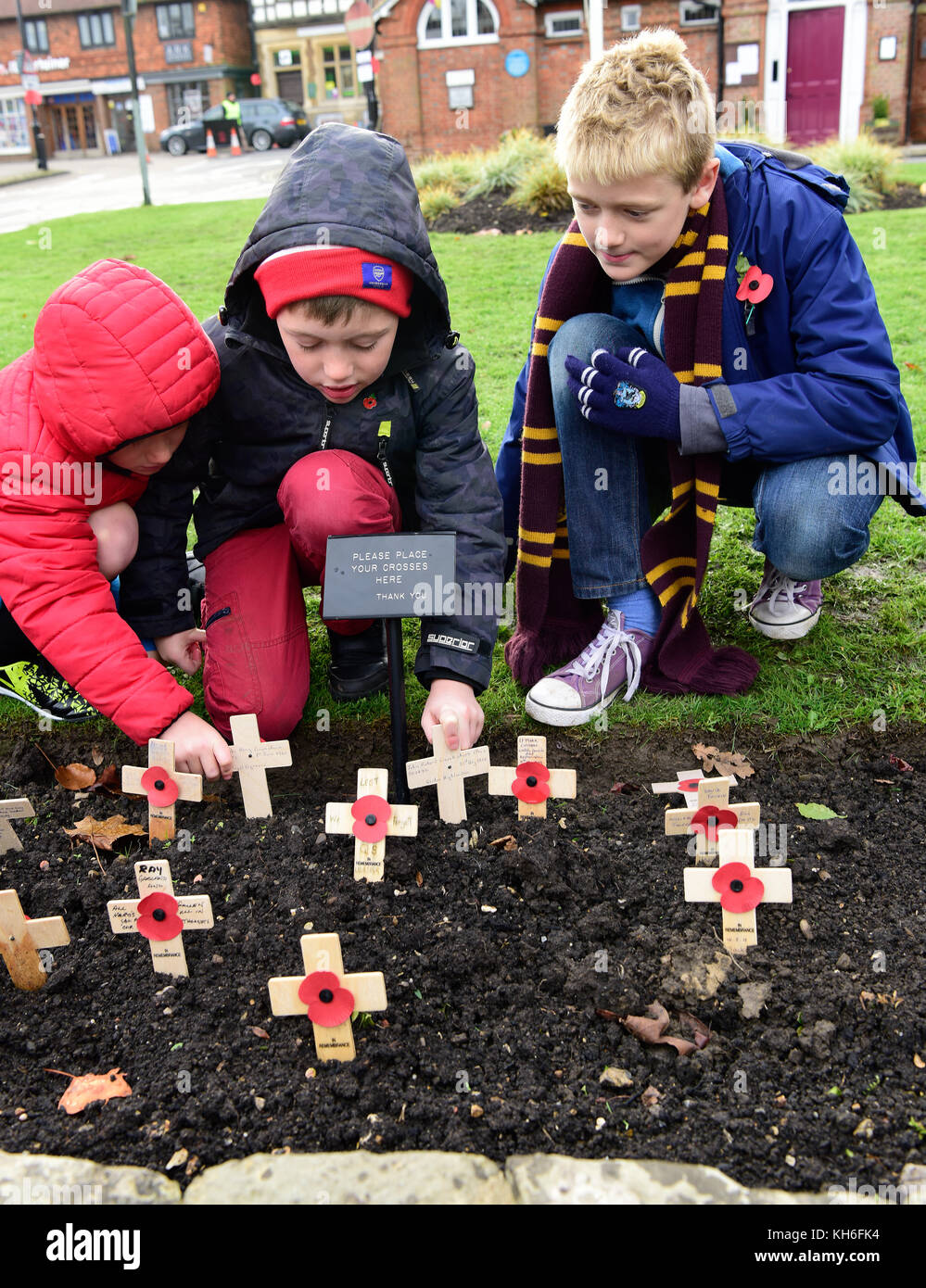 I bambini di piantare papaveri sul ricordo domenica, War Memorial, Haslemere, Surrey, Regno Unito. domenica 12 novembre 2017. Foto Stock