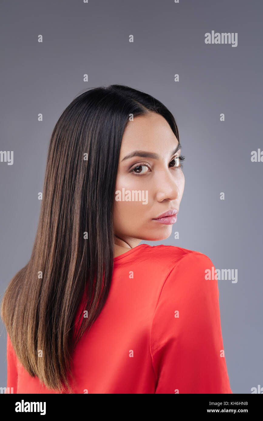 Splendida ragazza camminare nel suo abito rosso e guardando la calma Foto Stock