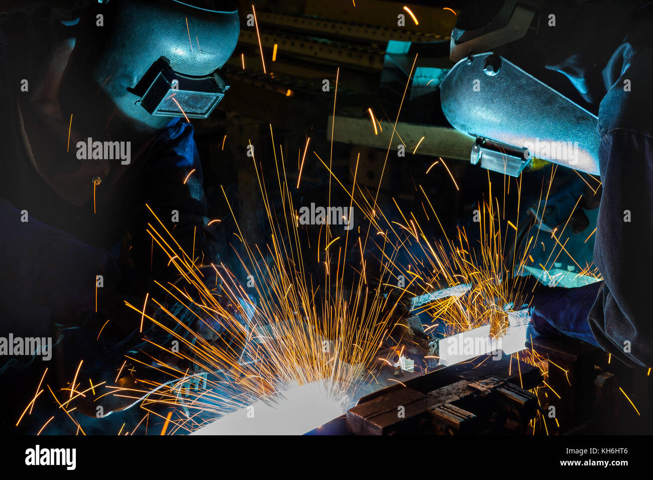 I lavoratori industriali con maschera protettiva di saldatura sono parte di autoveicolo Foto Stock