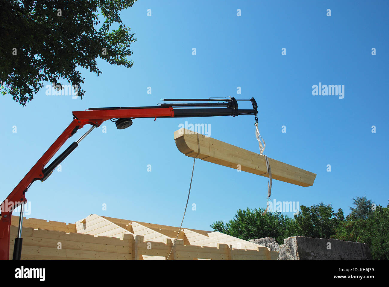 La trave principale viene abbassato in posizione su una parzialmente costruita in legno (FIR) blocco prefabbricato casa su un edificio nazionale sito Foto Stock