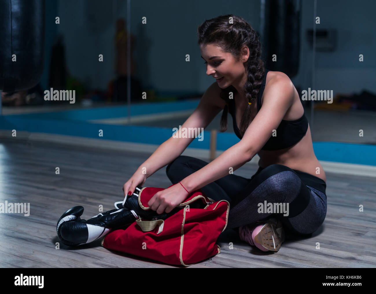 Giovane combattente ragazza boxer indossando guanti da boxe prima di partecipare al corso di formazione Foto Stock