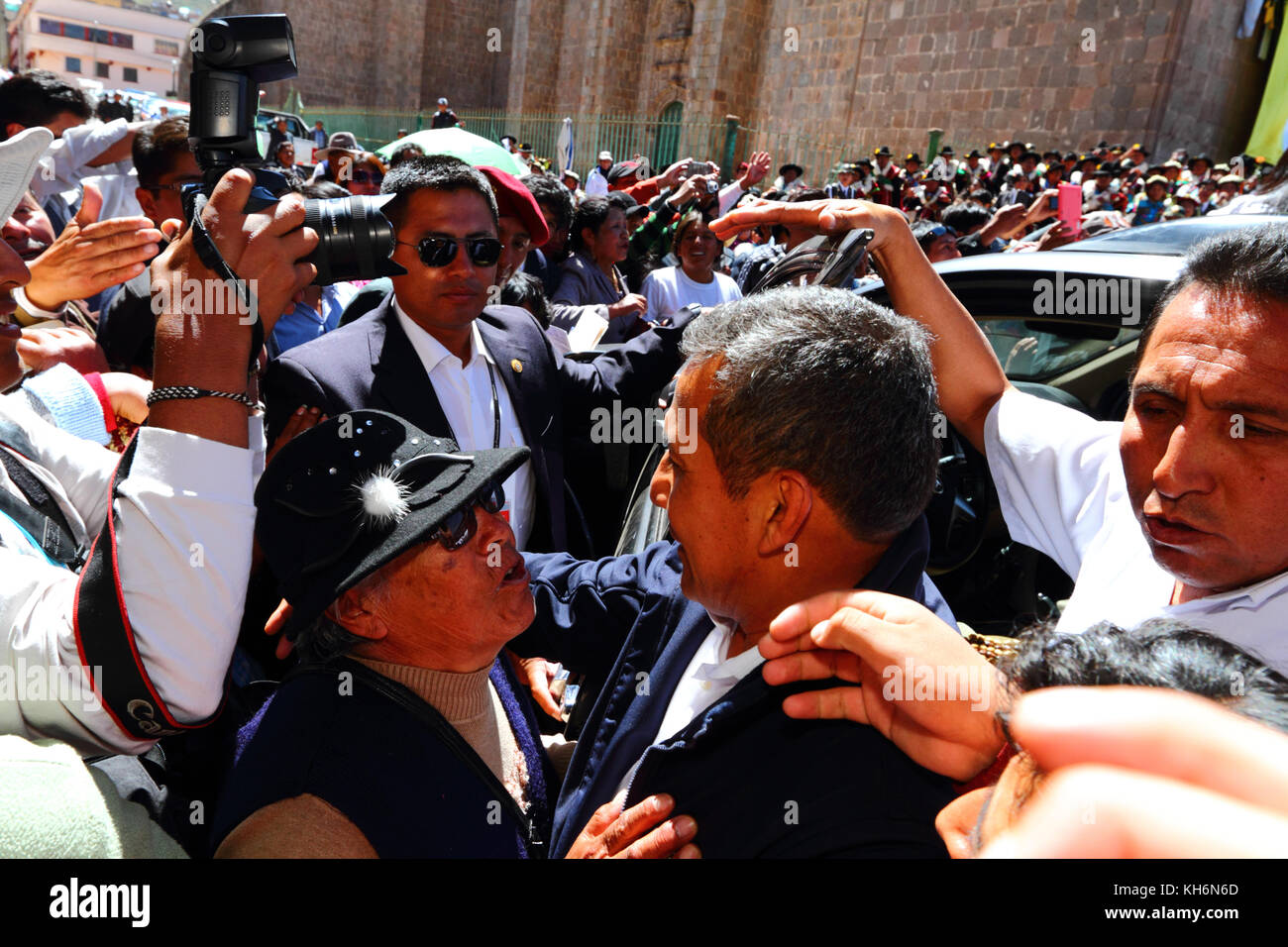 Una donna anziana dice addio al presidente Ollanta Humala (centro) come egli cerca di lasciare la Virgen de la Candelaria festival, Puno, Perù Foto Stock