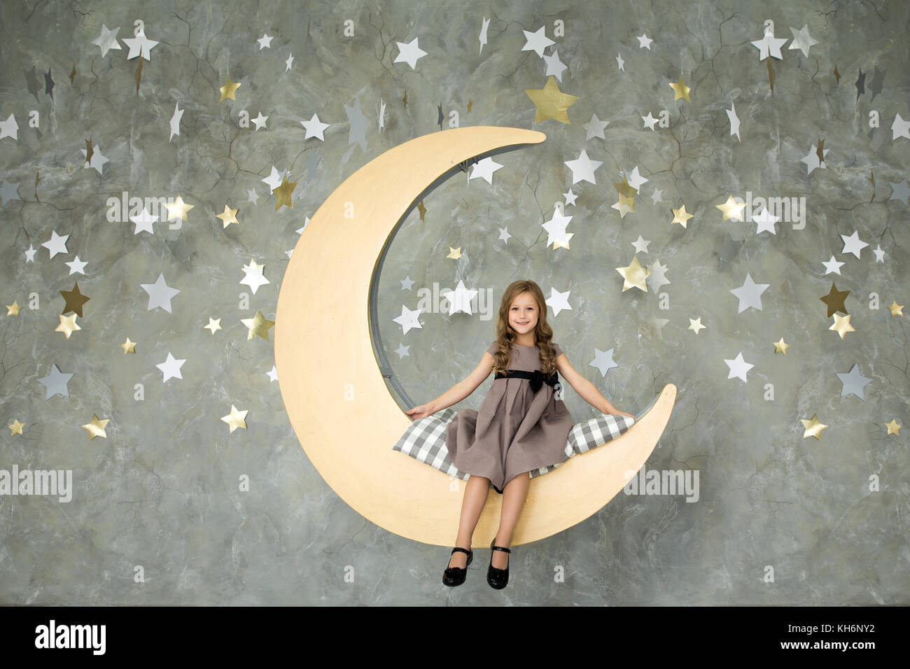 Bambina si siede su una luna gialla. Sweet Dreams. Foto Stock