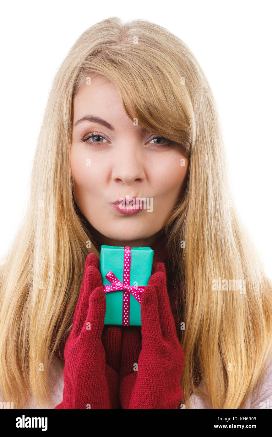 Donna sorridente in guanti di lana avvolto di contenimento regalo per Natale, Valentino, compleanno o altra celebrazione e invio di kiss Foto Stock