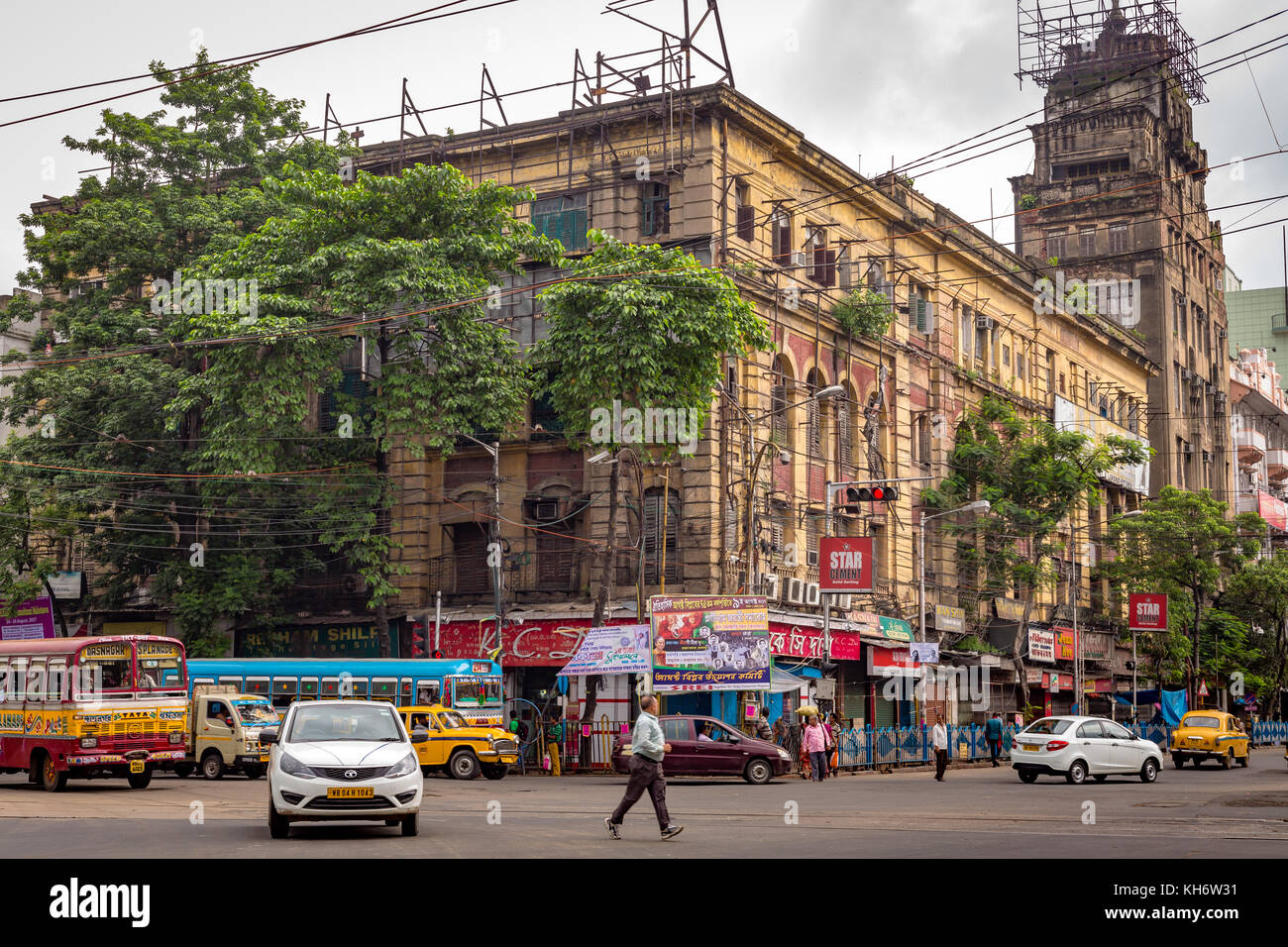Vista della strada indiana della città con traffico mattutino di fronte all'edificio storico coloniale all'Esplanade che attraversa Kolkata, Bengala Occidentale, India. Foto Stock