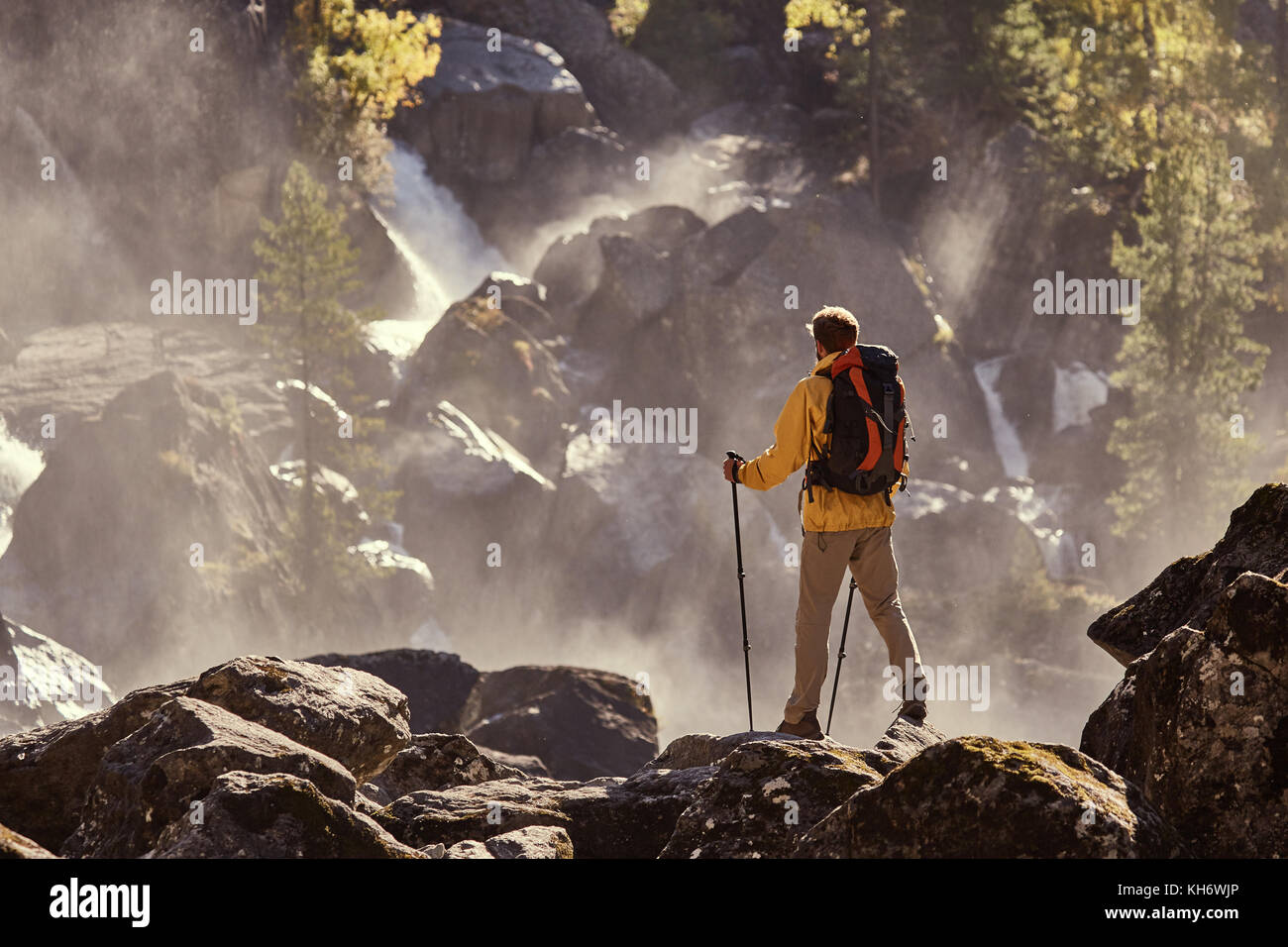 Escursionista escursionismo con zaino guardando la cascata nel parco in bella estate natura paesaggio. ritratto del maschio adulto torna in piedi all'aperto. Foto Stock