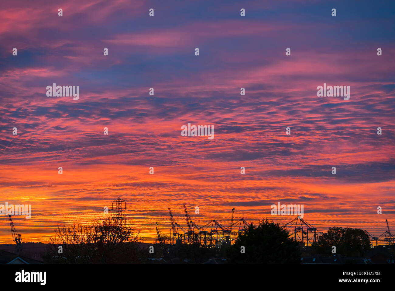Spettacolare colorata e vibrante il tramonto e il cielo di sera oltre il molo di Southampton, England, Regno Unito Foto Stock