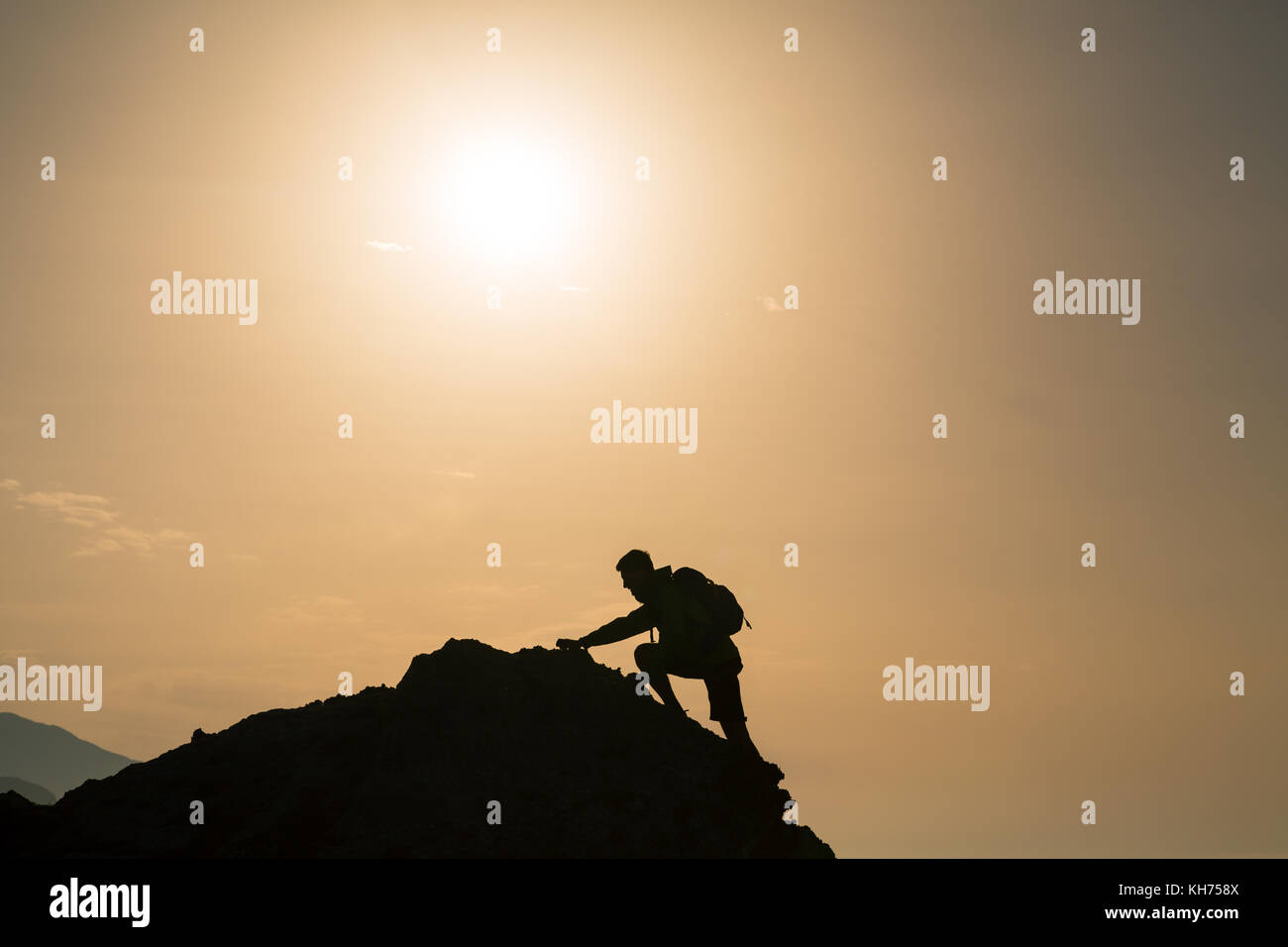 Arrampicata escursionismo silhouette di montagne e oceano, rocciatore in inspirational sunrise orizzontale sul picco di montagna. Compiuta montare l'uomo su sunrise un Foto Stock