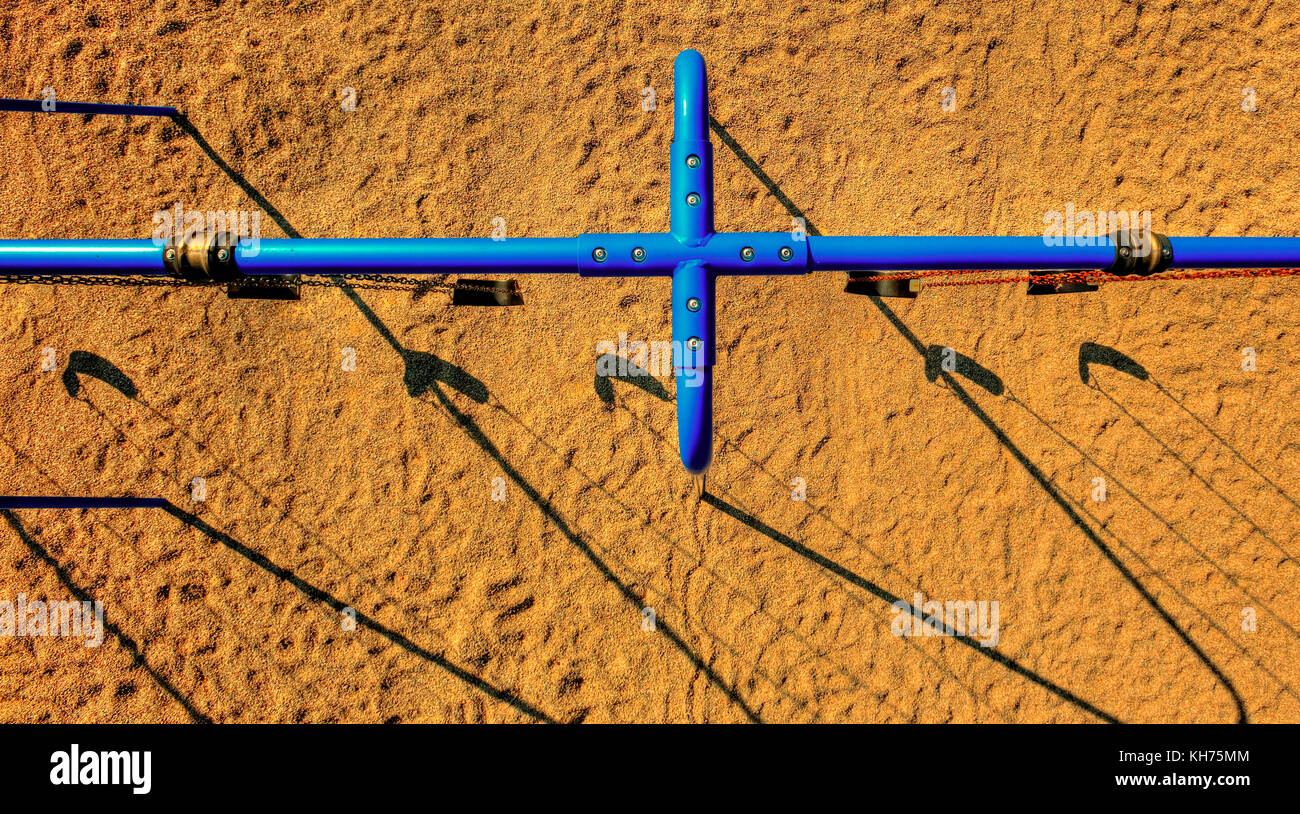 Antenna di polo HDR (high dynamic range) immagine di blu parco giochi oscilla su un fondo di sabbia. include modelli, linee e ombre. Foto Stock