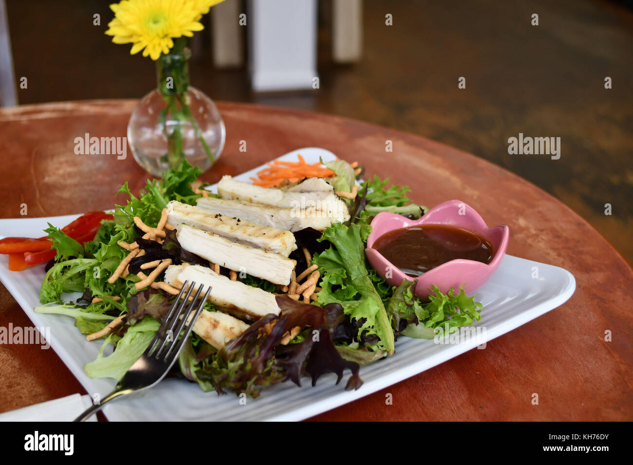 Una sana insalata di pollo con insalata di rucola in un informale cafe impostazione - il pranzo o la cena è delizioso con un pasto come questo! Foto Stock