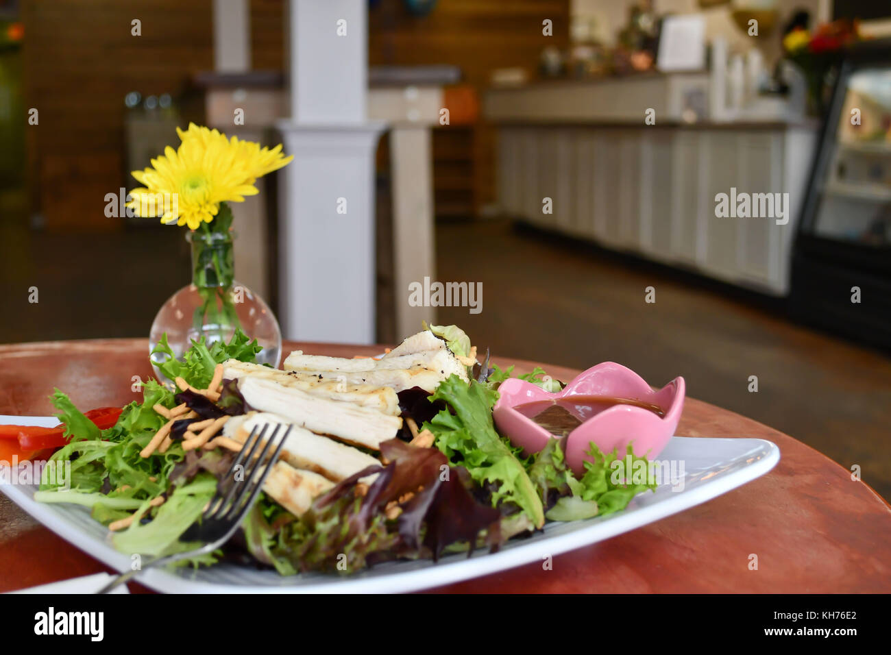Una sana insalata di pollo con insalata di rucola in un informale cafe impostazione - il pranzo o la cena è delizioso con un pasto come questo! Foto Stock