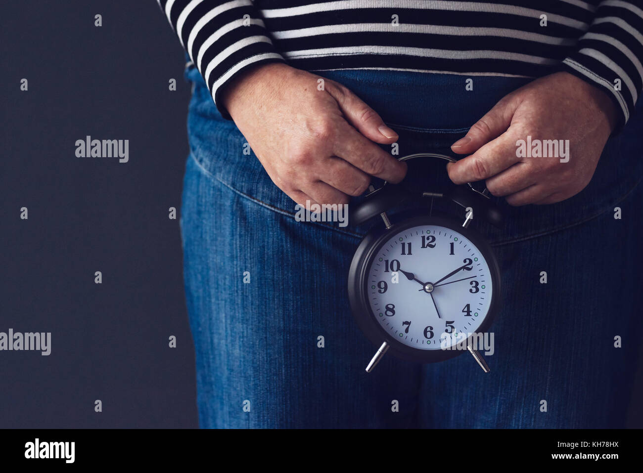 Il tempo passa, femmina mano azienda nero elegante vintage sveglia, il fuoco selettivo. concetto di salute riproduttiva controllo per le donne. Foto Stock