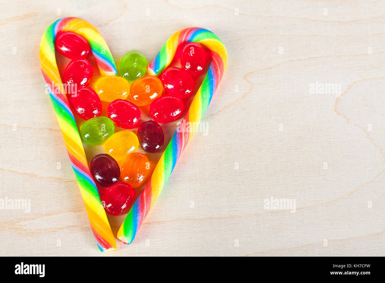 Il telaio dal cuore di caramelle colorate di caramelle di zucchero in legno per lo sfondo da su caramelle. caramelle colorate close up Foto Stock