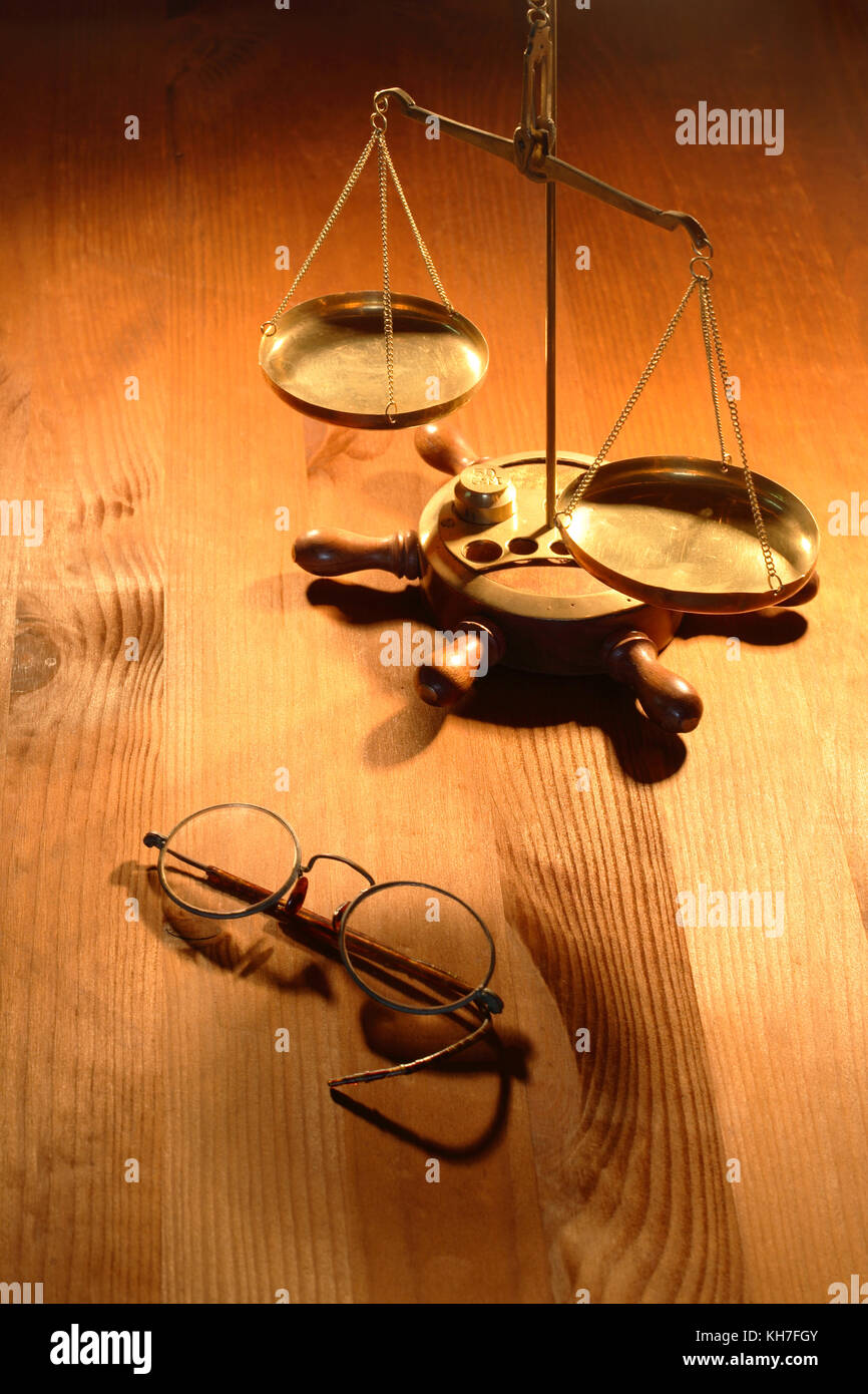 Ottone antico scala peso in piedi vicino a vecchi occhiali a Nizza lo sfondo di legno Foto Stock