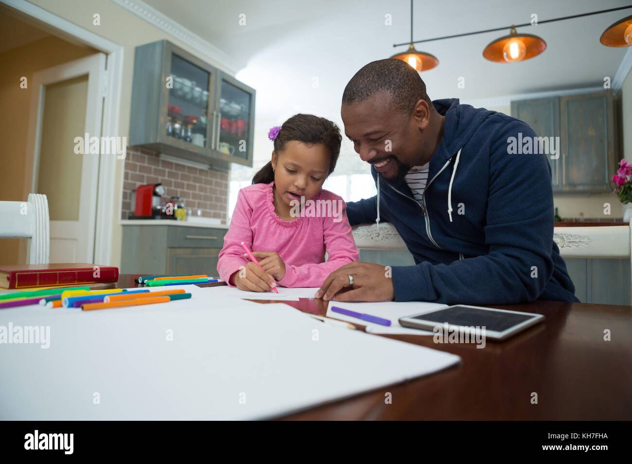 Padre aiuta a sua figlia con la sua scuola compiti a casa Foto Stock