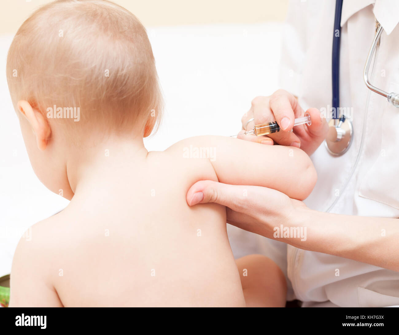 Close-up shot di pediatra pronti a dare una iniezione intramuscolare di un vaccino per una bambina Foto Stock