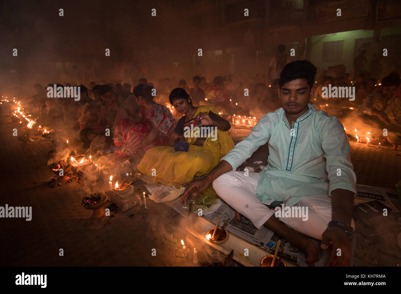 Dacca in Bangladesh. Il 14 novembre 2017. Devoti di partecipare con la preghiera a bruciare incenso e luce di lampade a olio prima di rompere il digiuno durante un festival religioso chiamato Rakher Upabash nel vicino a Dhaka il 14 novembre 2017. Popolo bengalese della fede indù in Bangladesh sedersi in preghiera per celebrare il XVIII secolo San indù Baba Lokenath con un 'Rakher Upobas " preghiera e digiuno giorno ogni anno migliaia di devoti indù si riuniscono di fronte di Shri Shri Lokenath Brahmachari Ashram tempio per il Rakher Upobash festival religioso in Barodi, vicino a Dacca in Bangladesh. Credito: Azim Khan Ronnie/Alamy Live News Foto Stock