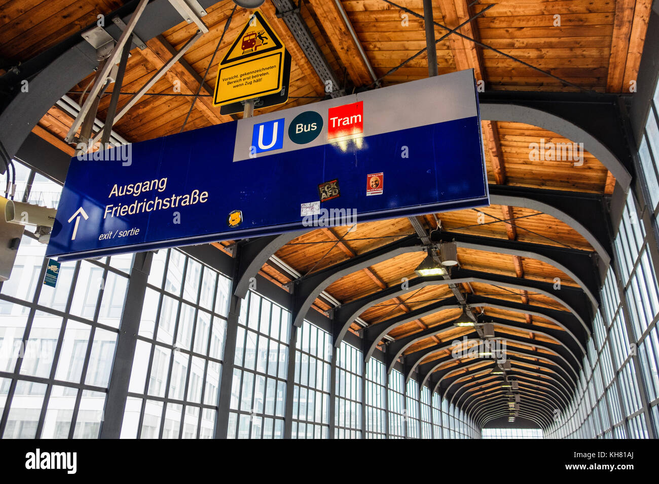 Germania Berlino,Friedrichstrasse stazione ferroviaria building interior , vetro storico & acciaio passaggio di uscita con soffitto in legno & information board Foto Stock