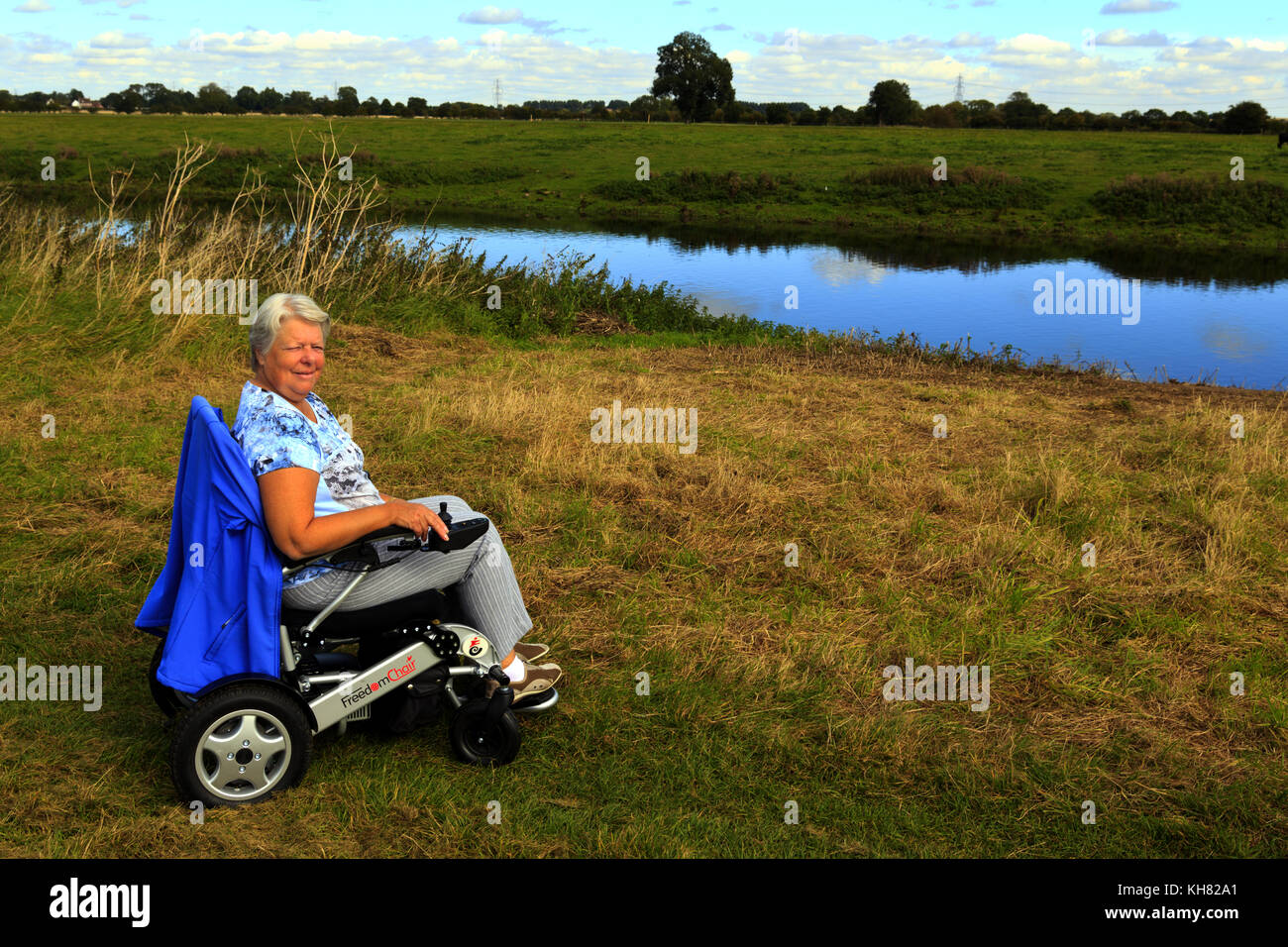 La donna in sedia a rotelle sul paese a piedi Foto Stock