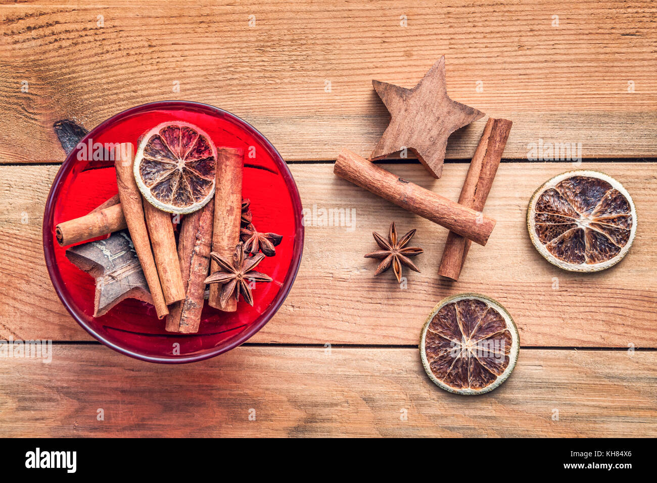 Ciotola di spezie di natale con secchi arancio e cannella su sfondo di legno, vintage decorazioni di Natale Foto Stock