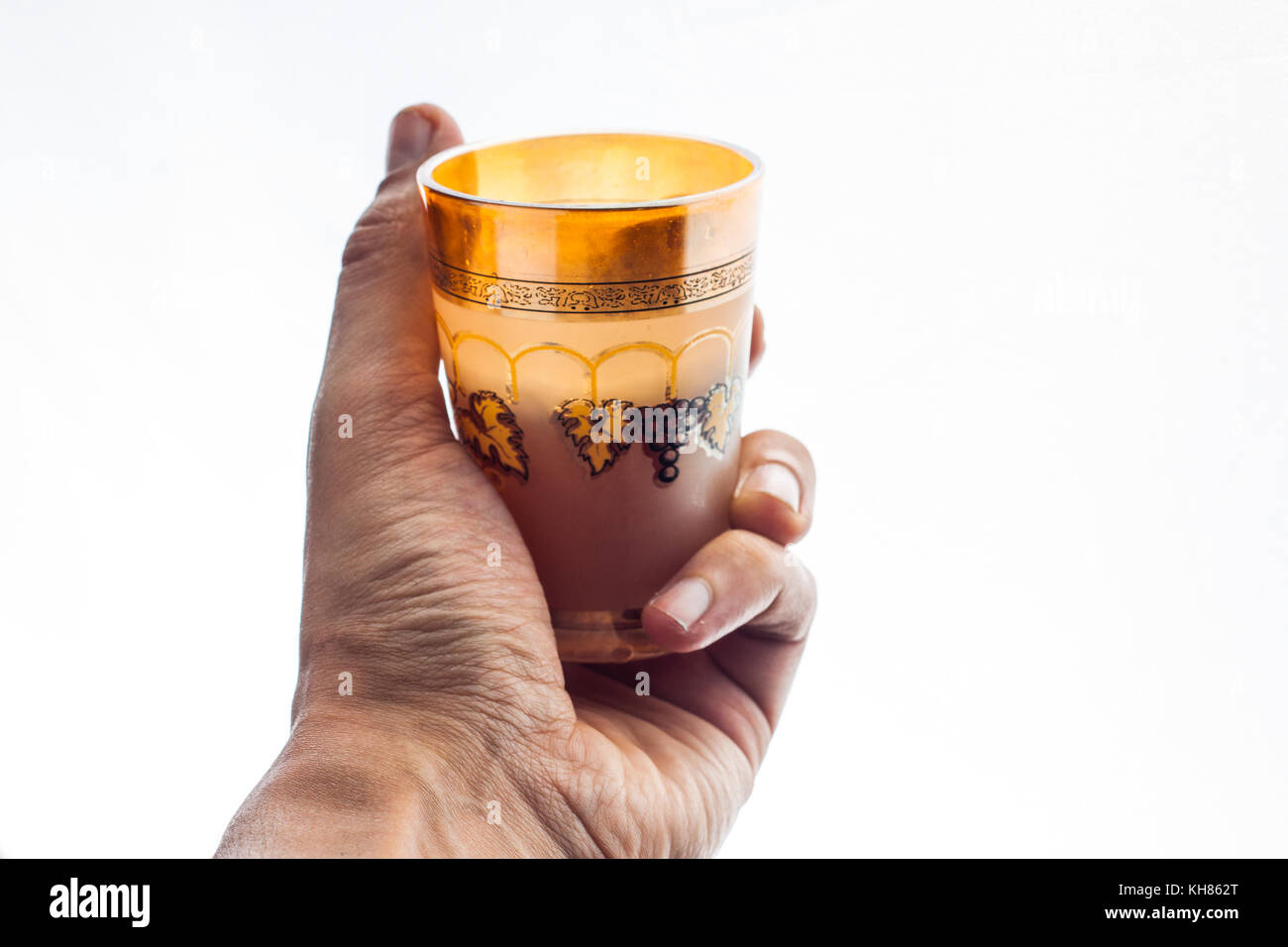 Primo piano di una mano che tiene un marocchino bicchiere di tè Foto Stock