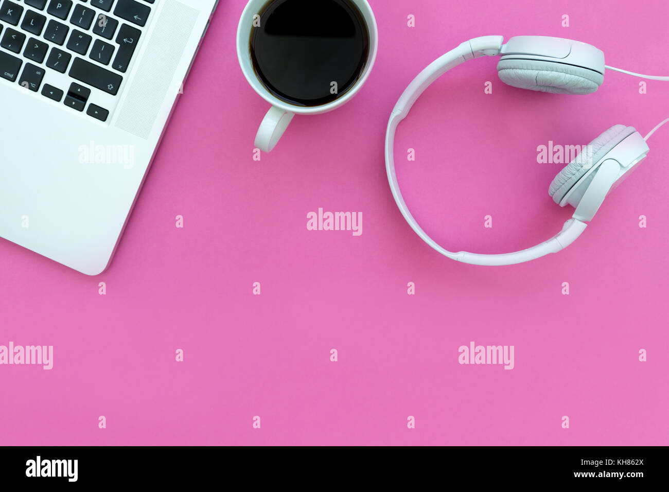 Cuffie per musica tastiera del computer portatile e del caffè su sfondo rosa Foto Stock