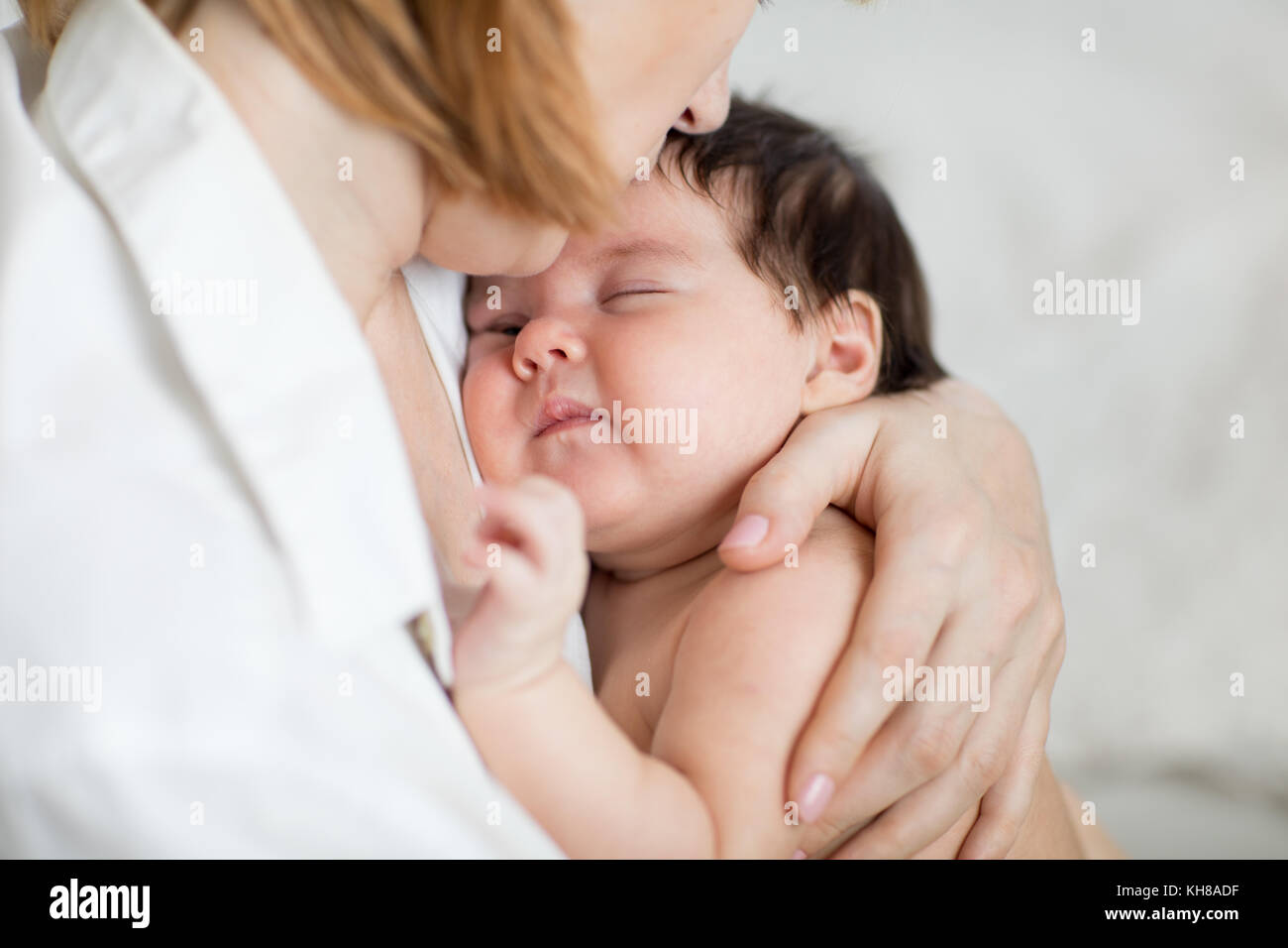 La mamma mentre tiene il suo bambino figlia. baby è addormentato nella madre di braccia Foto Stock