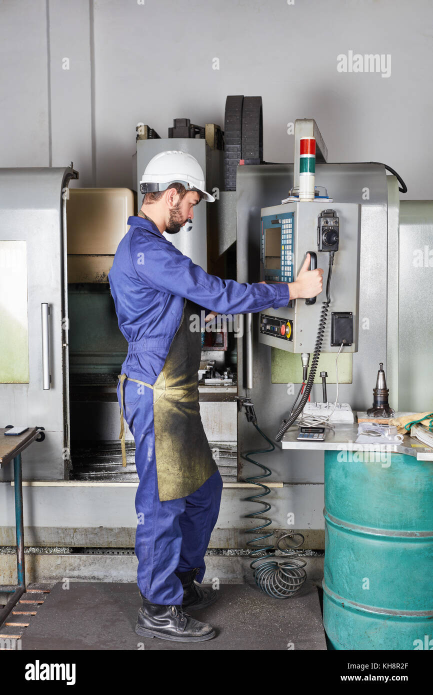 Lavoratore programma macchina CNC in officina di metallurgia Foto Stock