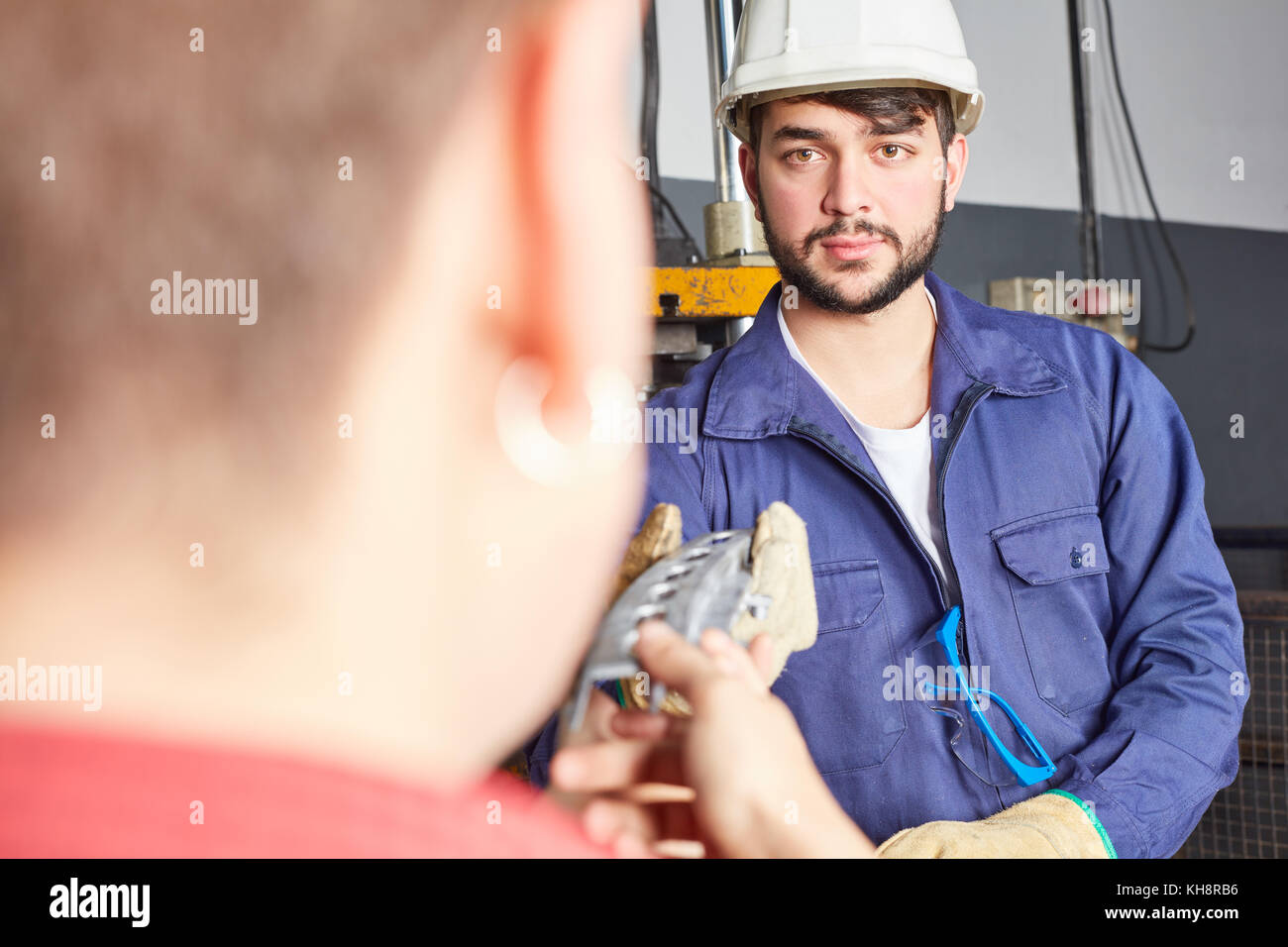L uomo come industria apprendista con abbigliamento protettivo in officina di metallurgia Foto Stock