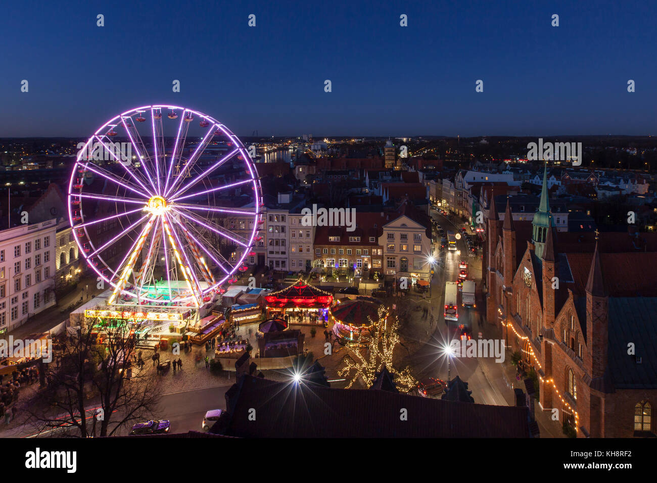 Ruota panoramica illuminata al mercatino di Natale serale in inverno a Koberg, Hanseatictown Luebeck, Germania Foto Stock