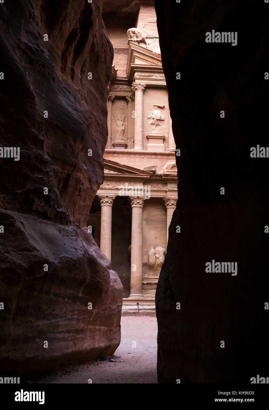 Rosa pietra arenaria scolpita di Nabataean tesoro, Al Khazneh, visto attraverso la stretta apertura nella gola di alte pareti del Siq, Petra, Giordania, Medio Oriente Foto Stock