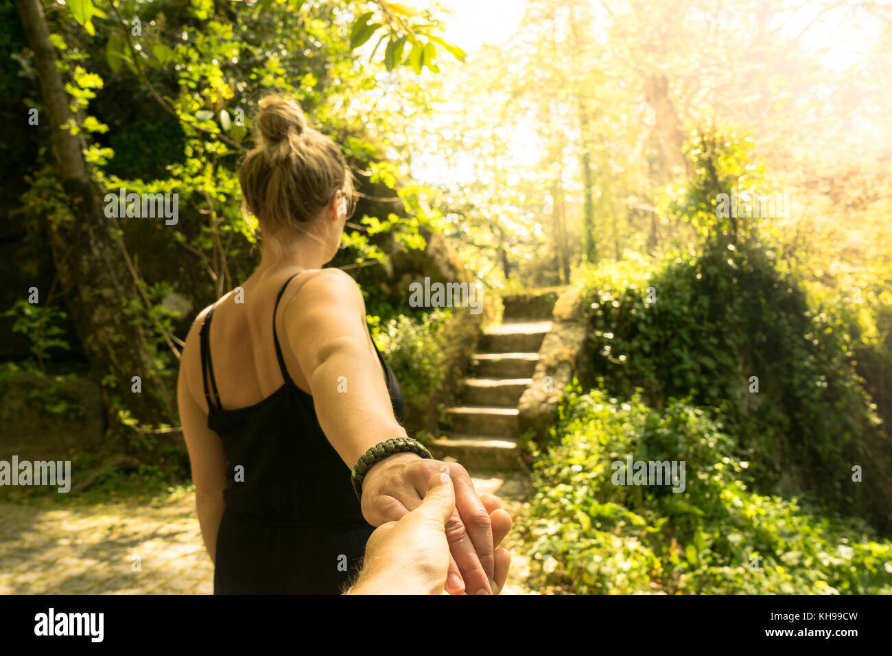 Coulple tenendo le mani in un giardino. Camminare insieme verso le scale. Foto Stock