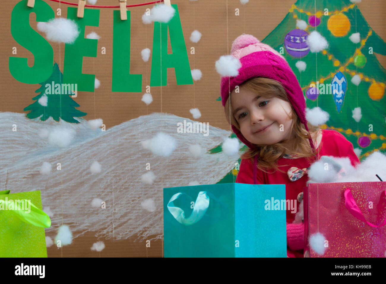 Vendita, natale, vacanze e concetto di persone - baby sorridente in abito rosso con segno di vendita e borse Foto Stock