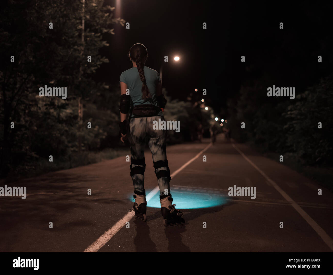 Rullo di Sport pattinaggio ragazza di notte utilizzando la torcia elettrica o fiaccole. Foto Stock