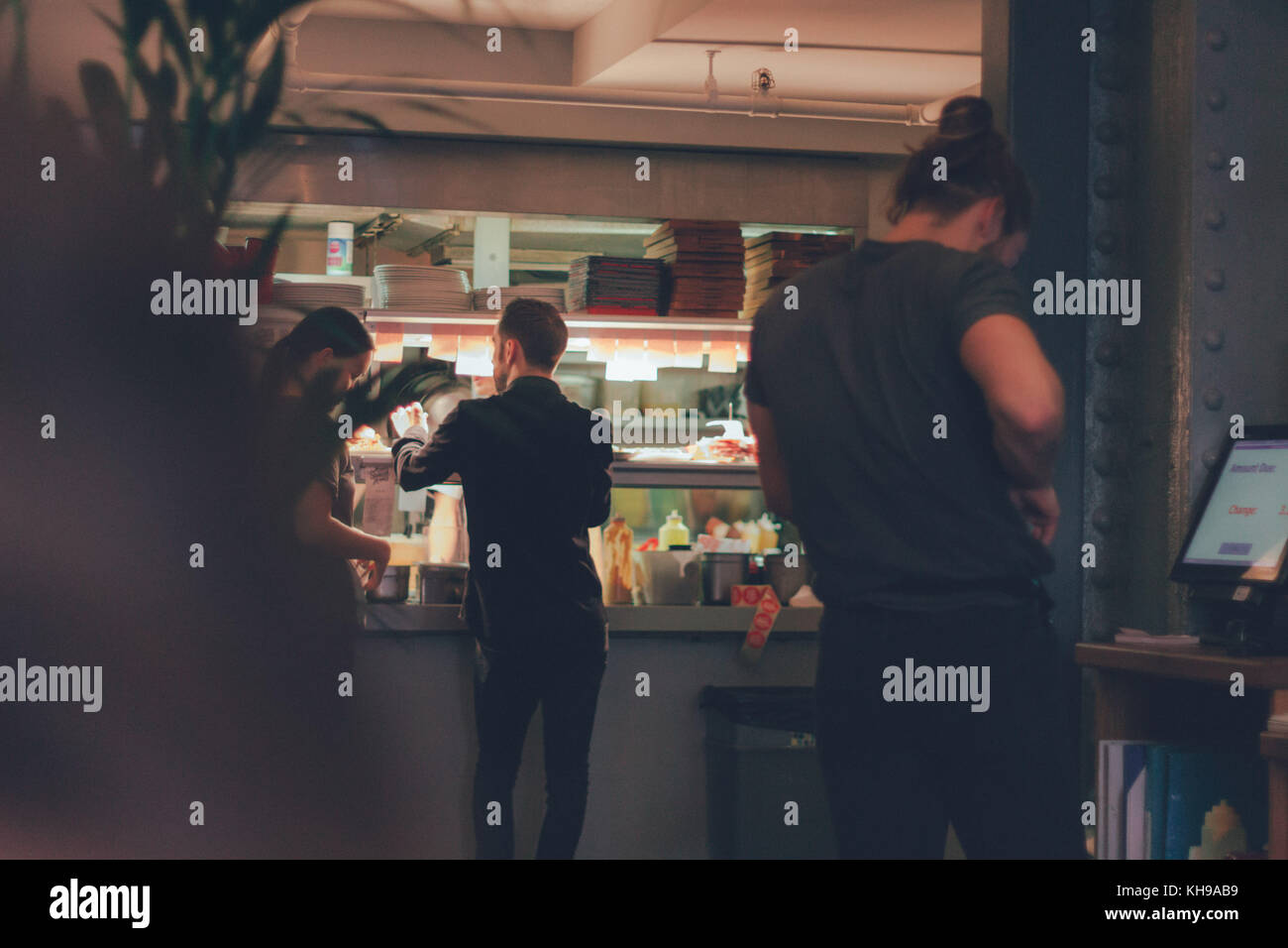 Occupato il personale del ristorante che serve di lavoro e invio di alimenti e bevande per le tabelle Foto Stock