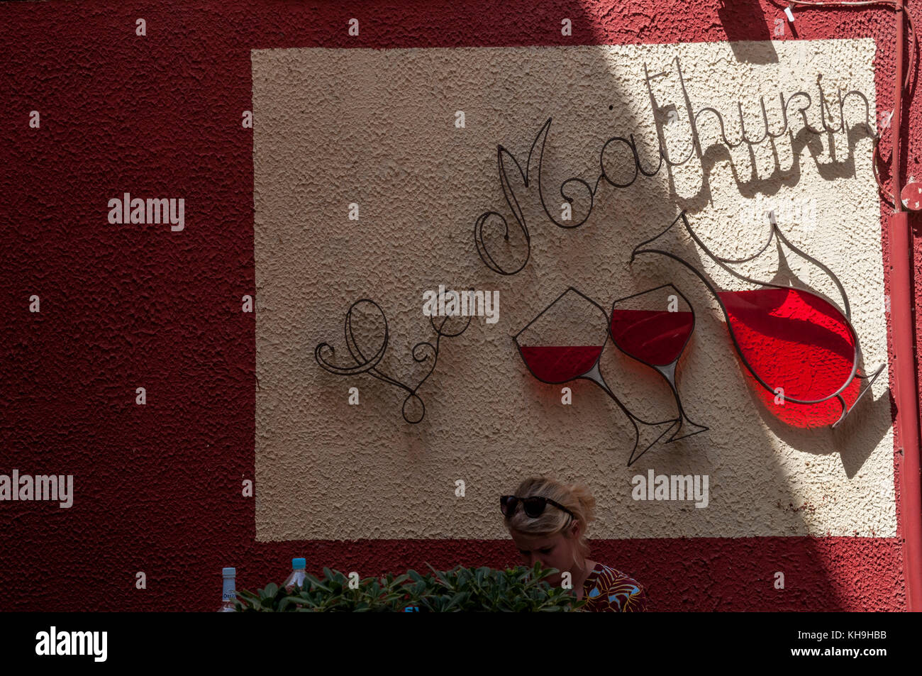 La corsica : una donna seduta in una delle tante enoteche nei vicoli di saint-Florent, estate popolare luogo di vacanza noto come le corse saint-tropez Foto Stock