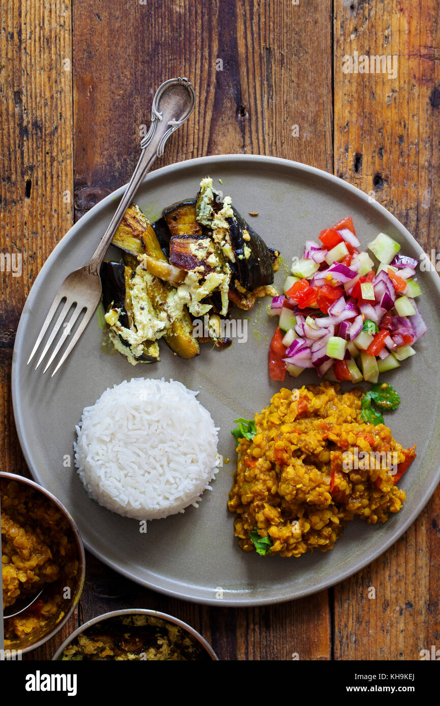 Pasto indiano con masoor dal - curry di lenticchie, dahi baingan, riso e insalata mista Foto Stock