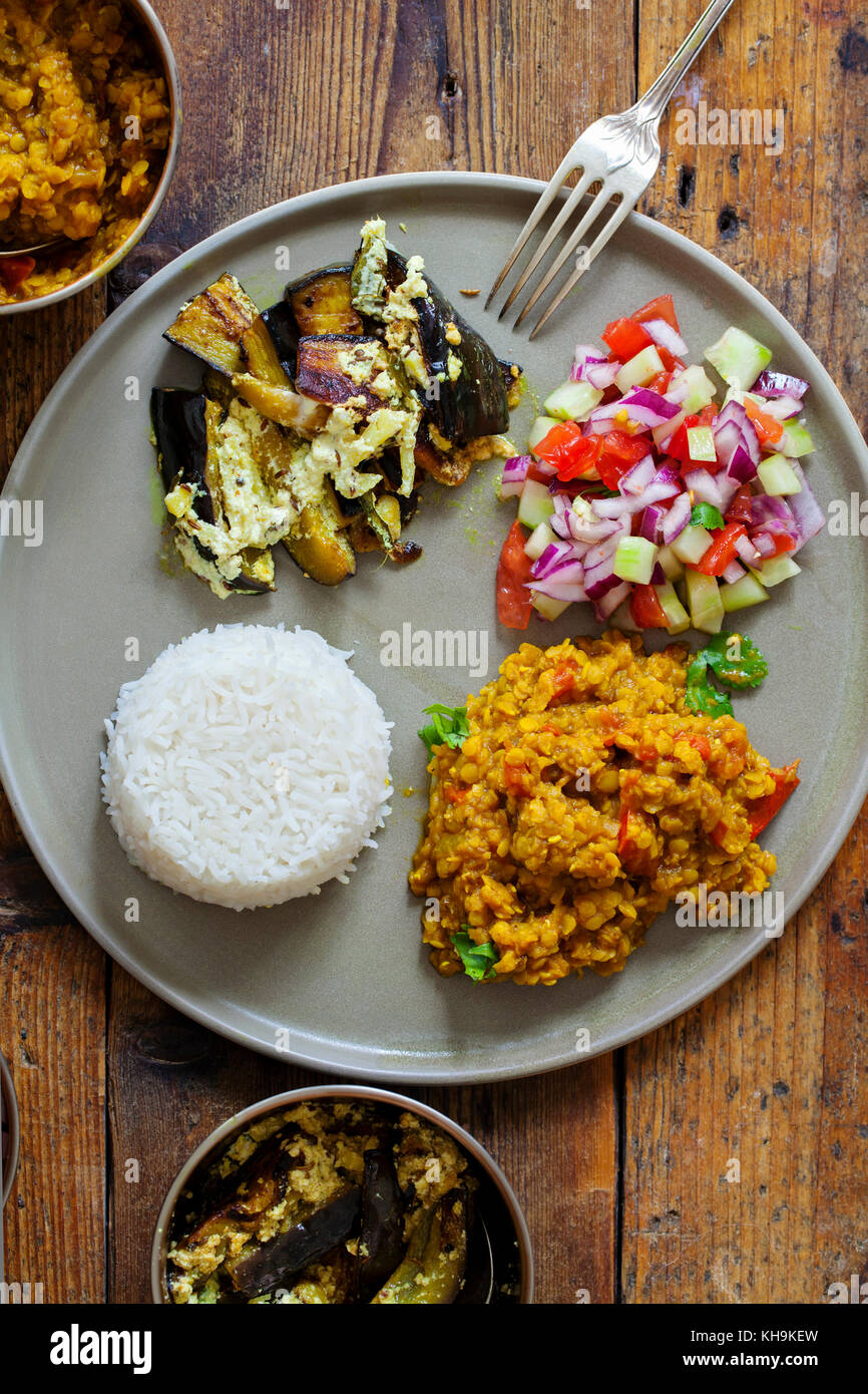 Pasto indiano con masoor dal - curry di lenticchie, dahi baingan, riso e insalata mista Foto Stock