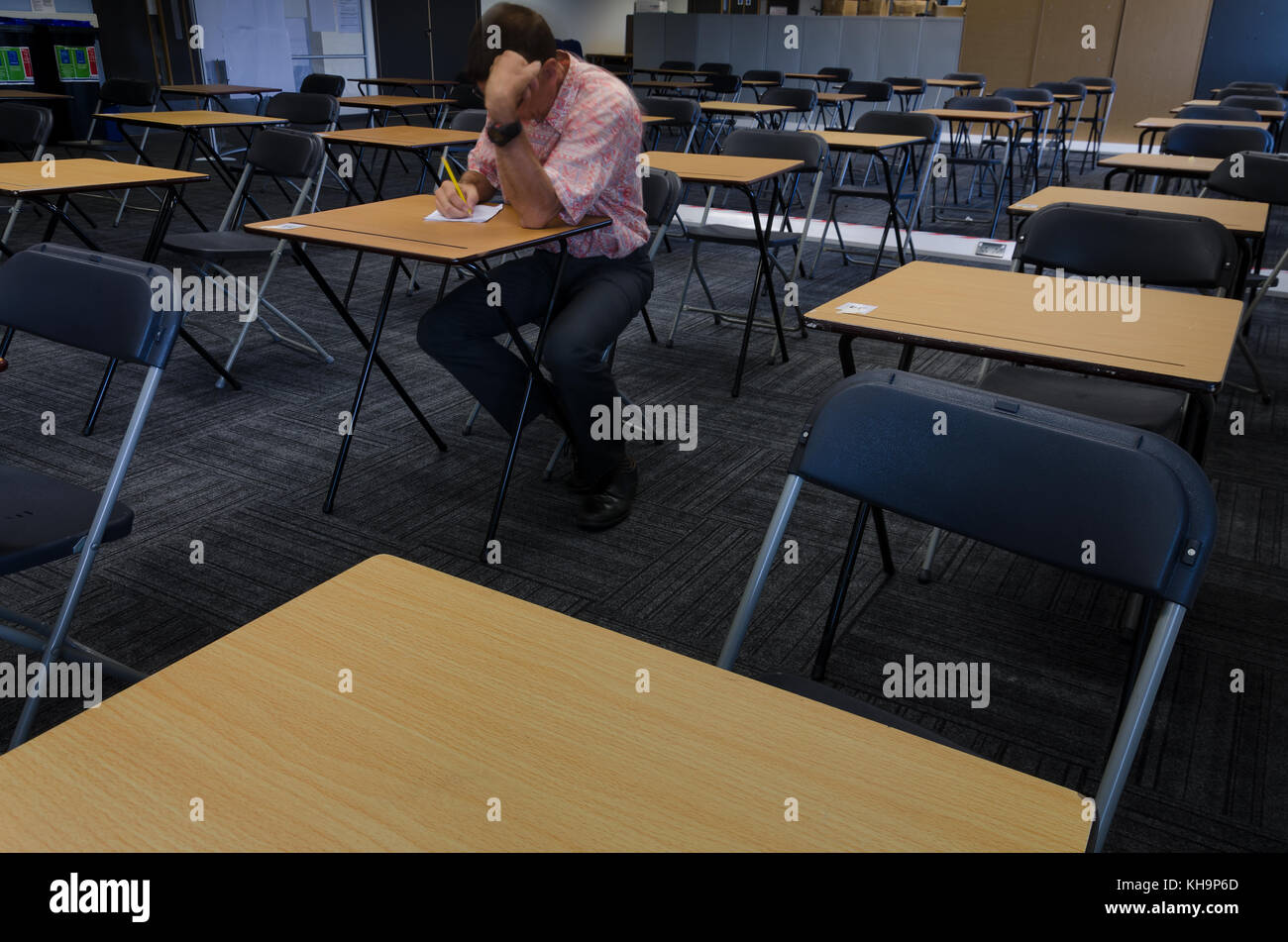 Seduta da sola un esame per la lingua inglese e matematica matematica esami GCSE singola persona solitaria piuttosto solitaria come dato tempo extra a causa di disabilità Foto Stock