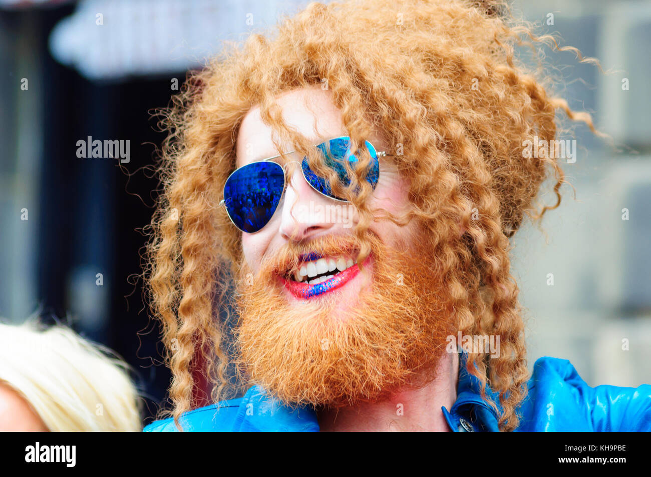 7ft tall trascinare artista Gingzilla con zenzero intrecciato di capelli, barba e baffi blu da indossare occhiali a specchio durante la Edinburgh Fringe Festival Foto Stock