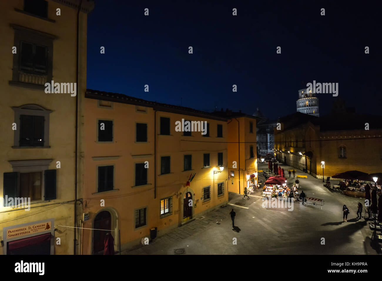 A tarda notte fotografia da Pisa Italia che mostra la torre pendente di Pisa illuminata la distanza su una strada vuota con un cafe Foto Stock