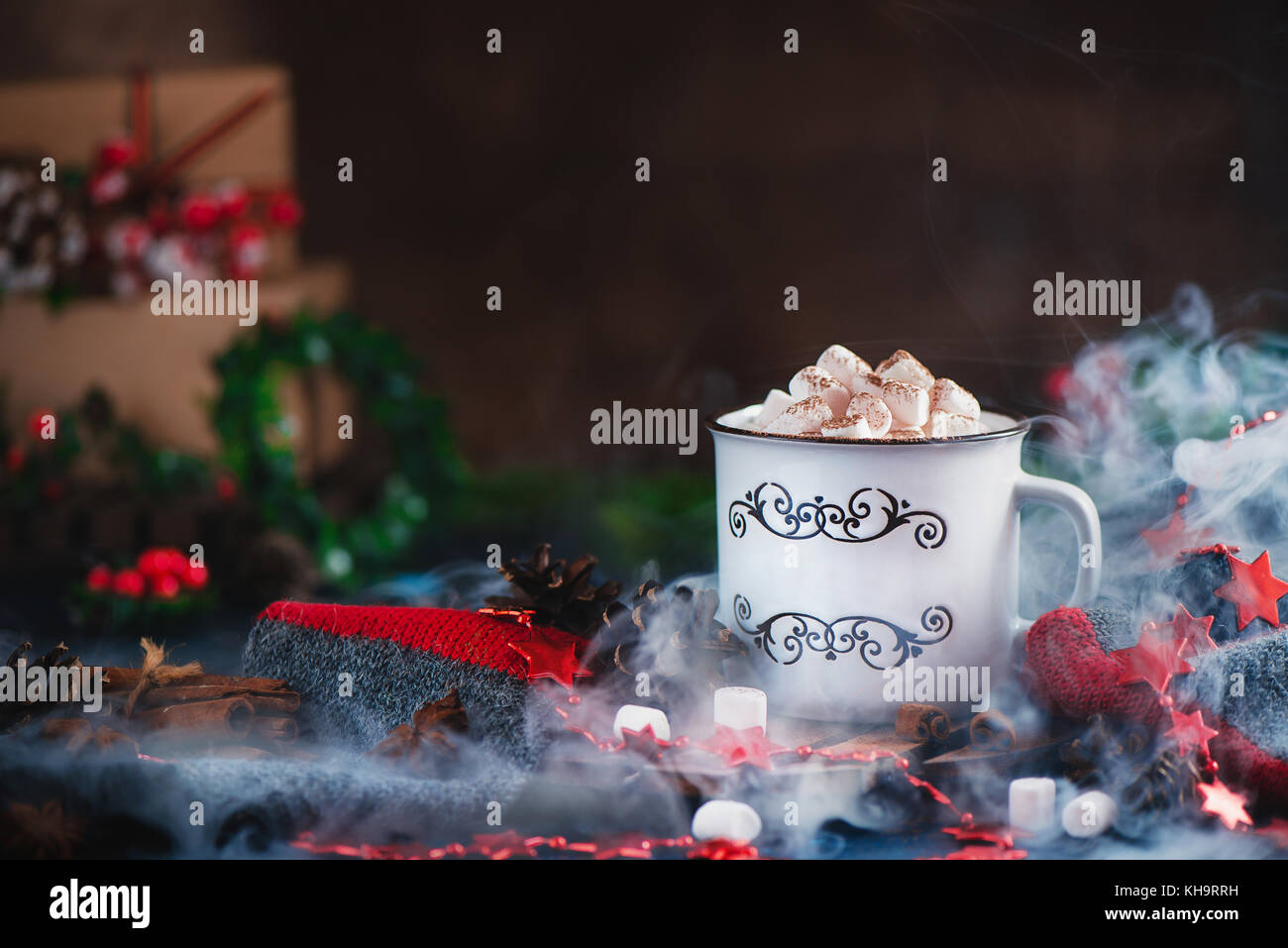 Cioccolata calda con marshmallows in un accogliente smalto la tazza con il vapore e le decorazioni di Natale Foto Stock
