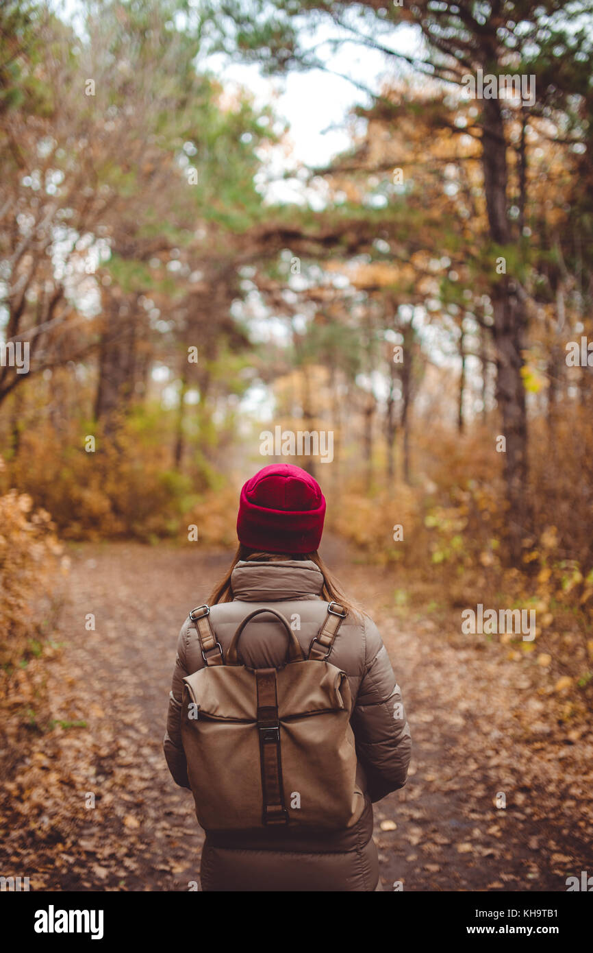 Giovane donna in abbigliamento casual in piedi nella foresta di autunno. Foto Stock