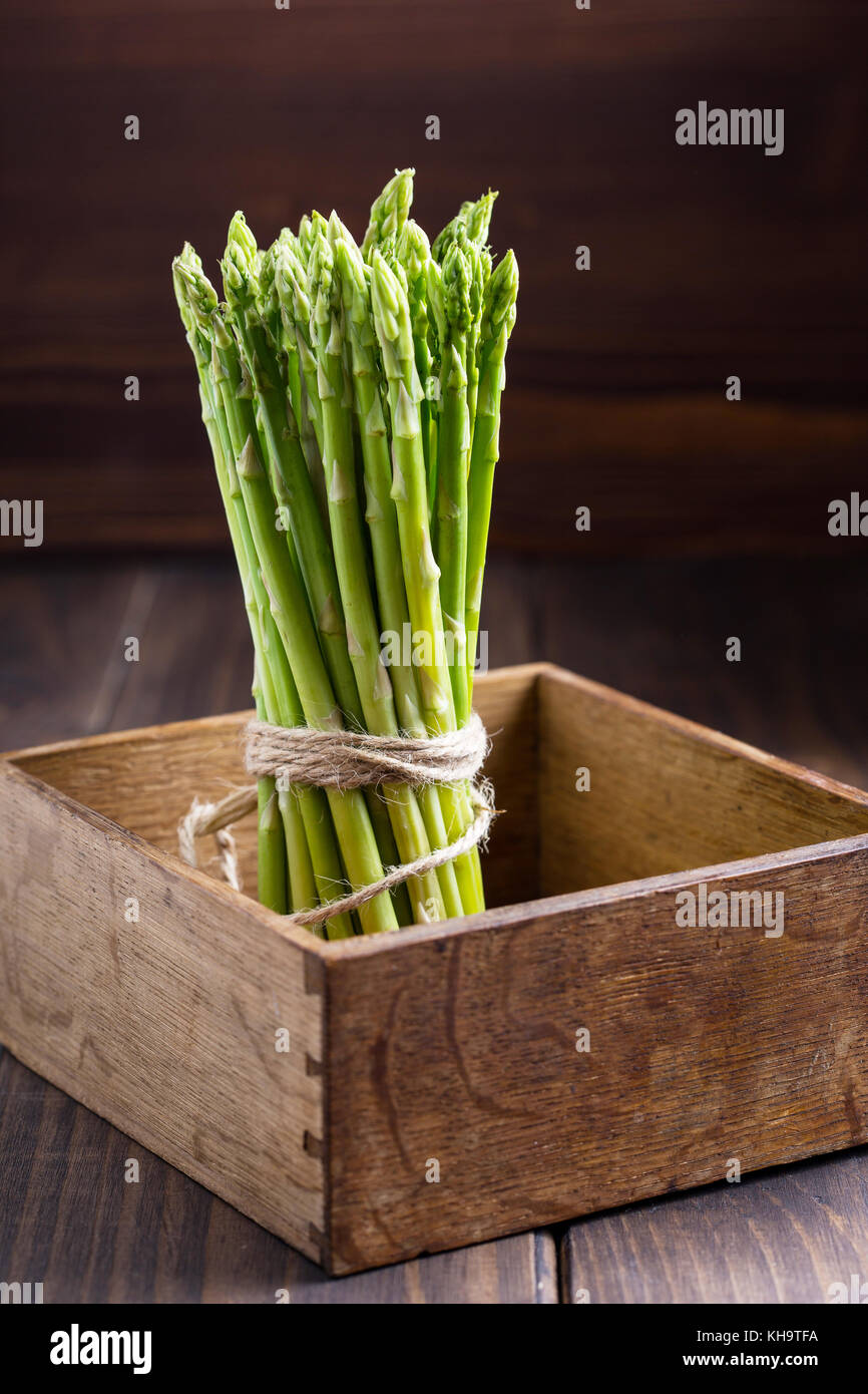 Mazzetto di giovani asparago verde in un rustico di scatola di legno Foto Stock
