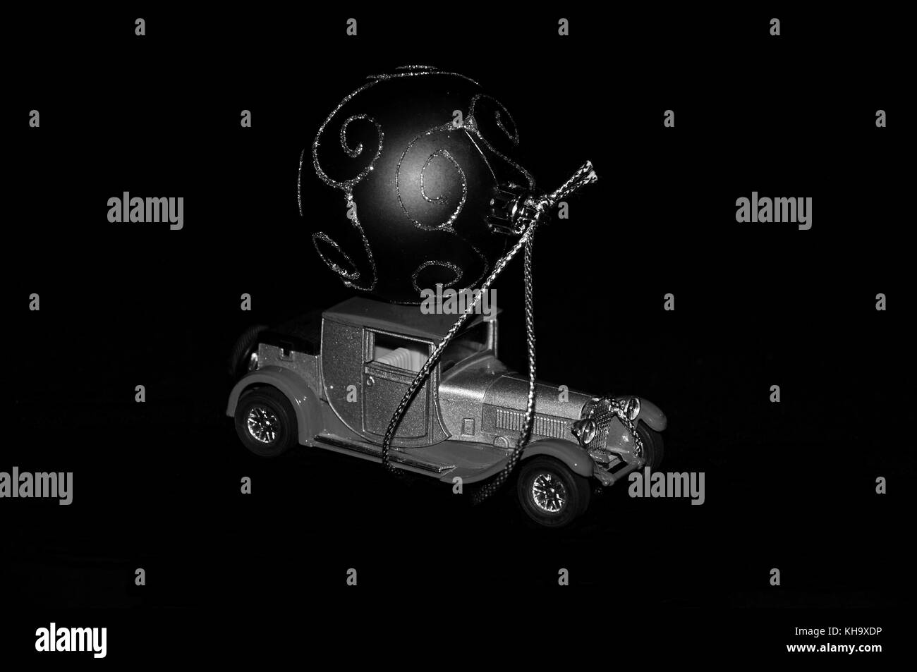 Un artistico e creativo dimostrando setup natale e spirito festivo. Un gigante di ornamento di Natale legato a un'auto d'epoca tetto Foto Stock