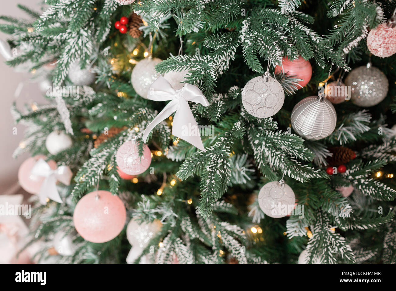 Albero di Natale decorato con i giocattoli in argento e colore rosa. in  essa possiamo vedere i palloncini con dei nastri e luci incandescente  garland Foto stock - Alamy