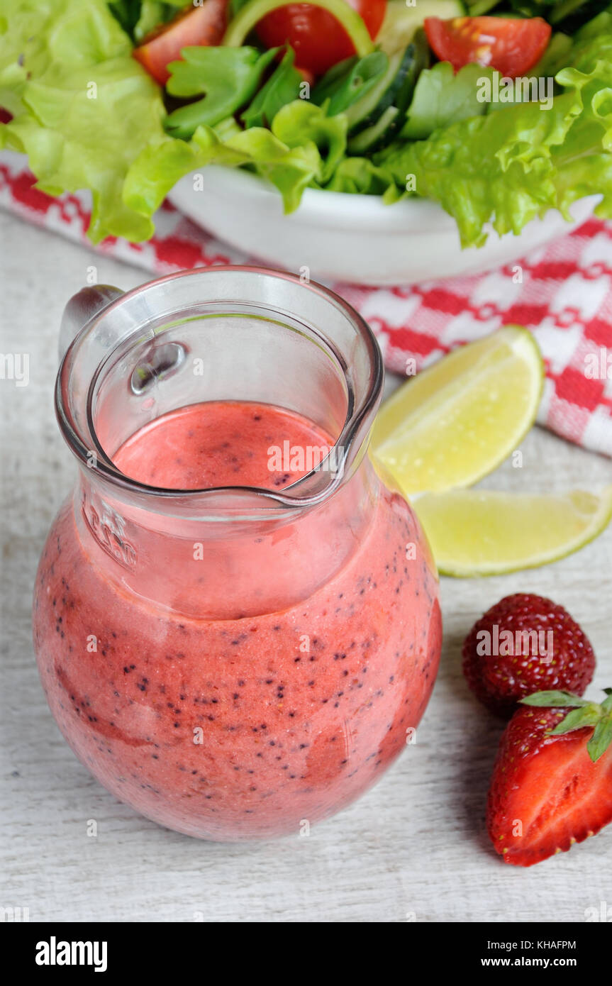 Fragole fresche con salsa di menta, semi di papavero e calce in un vetro sauceboat Foto Stock