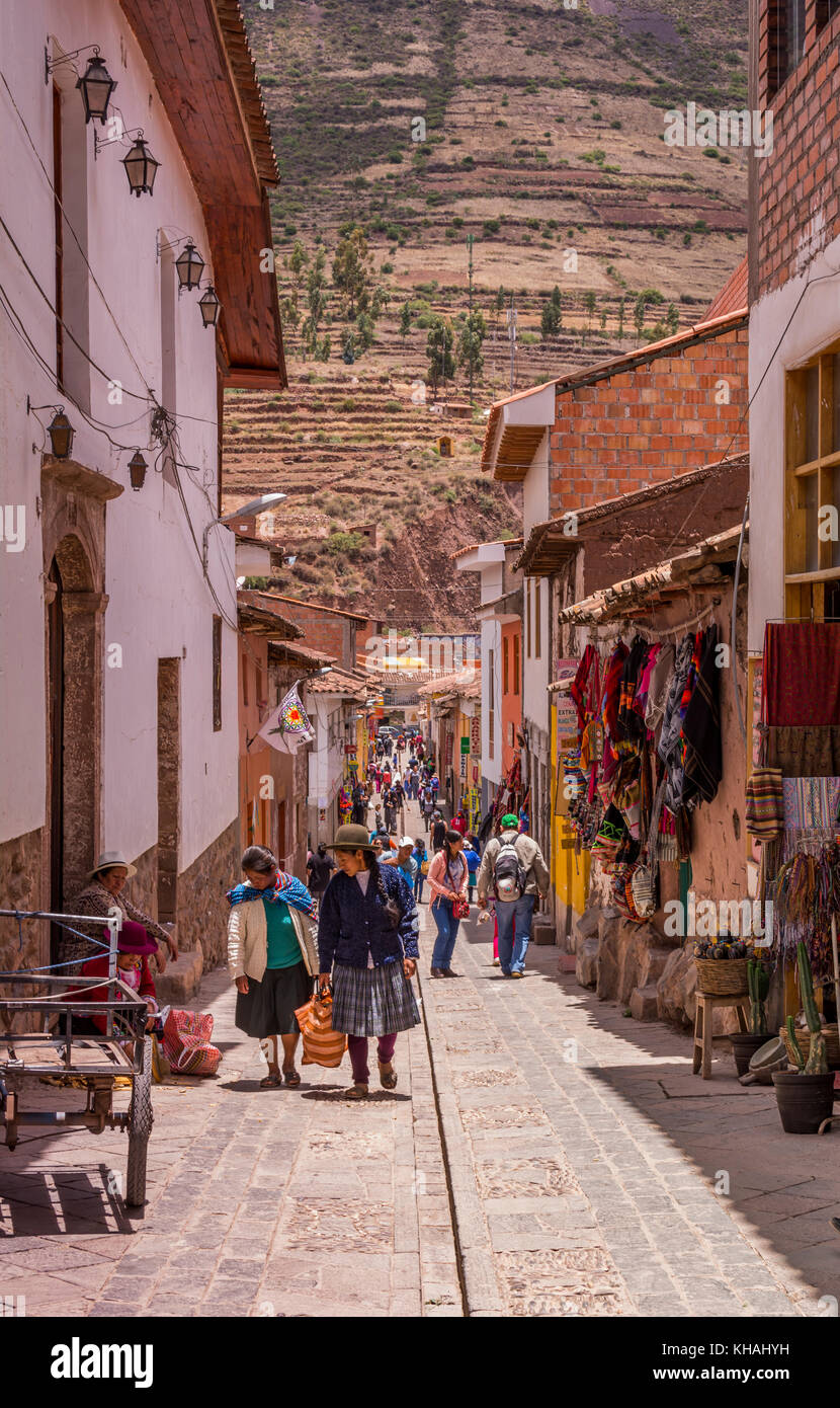 Il Perù la gente del posto e i turisti shop lungo una stretta strada coloniale di Pisac, Pisaq, Perù, Valle Sacra, Sud America. Foto Stock